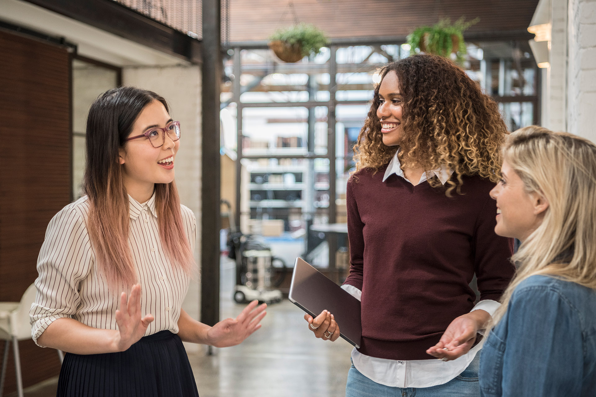 Three young women having conversation and laughing