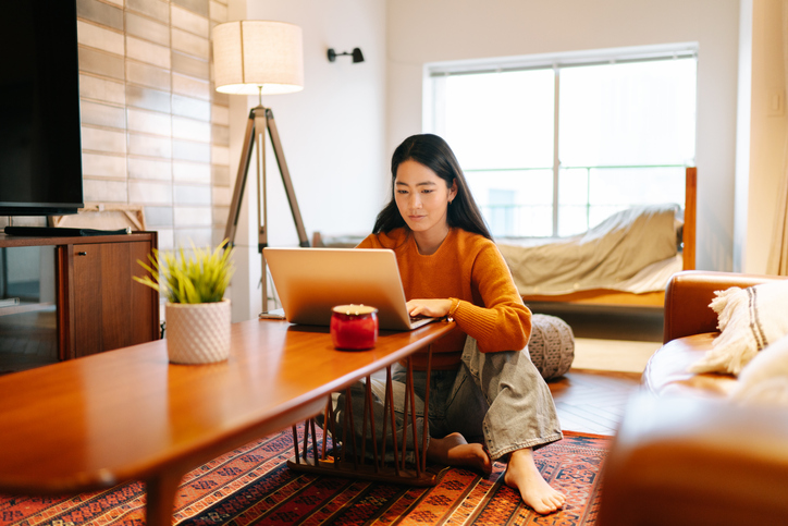 Young woman using laptop comfortably at home